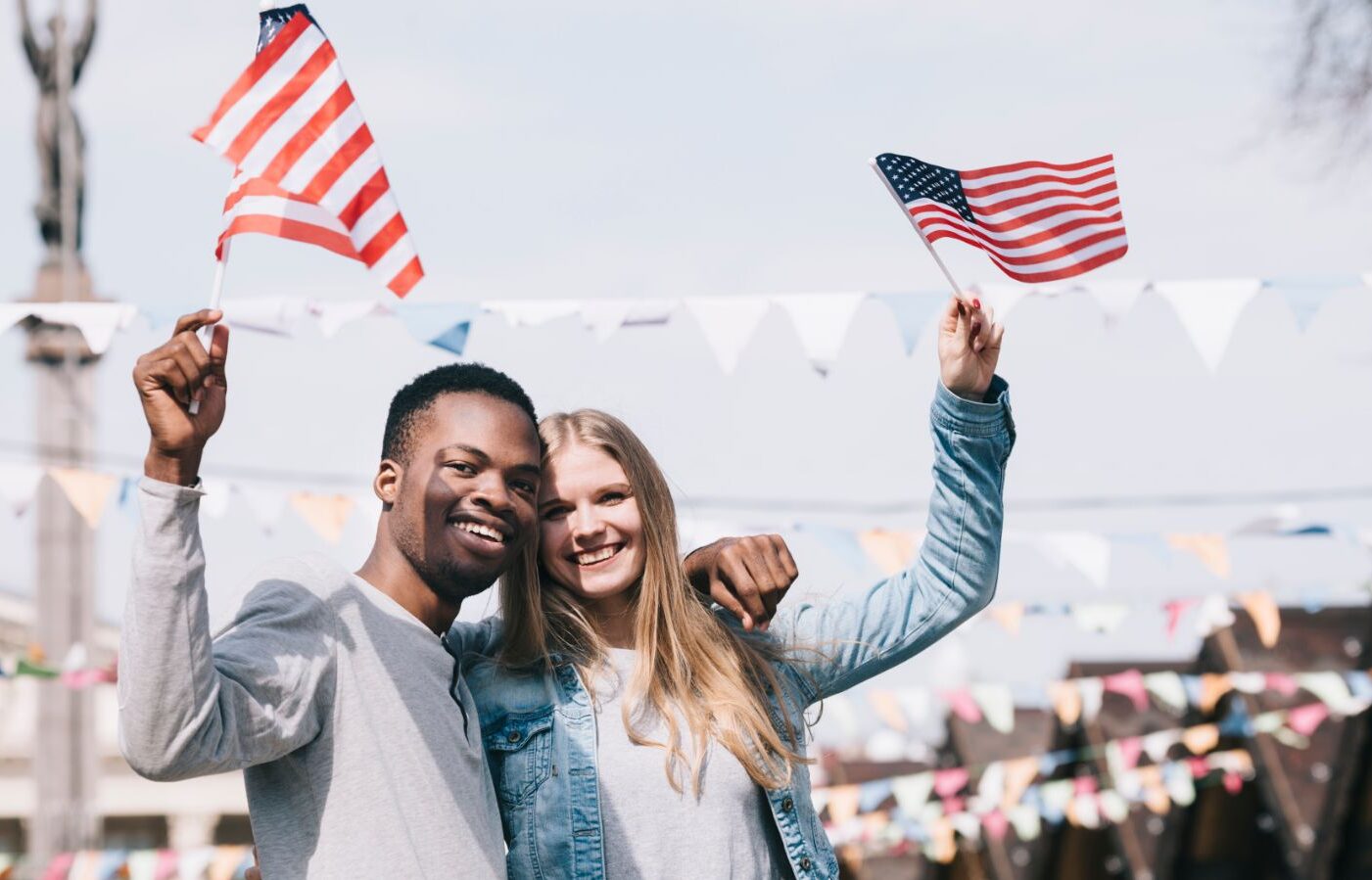 Dois amigos com bandeiras dos EUA aproveitando uma viagem com o visto americano