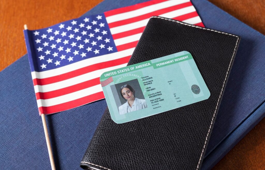 Green Card ao lado de uma bandeira dos Estados Unidos.