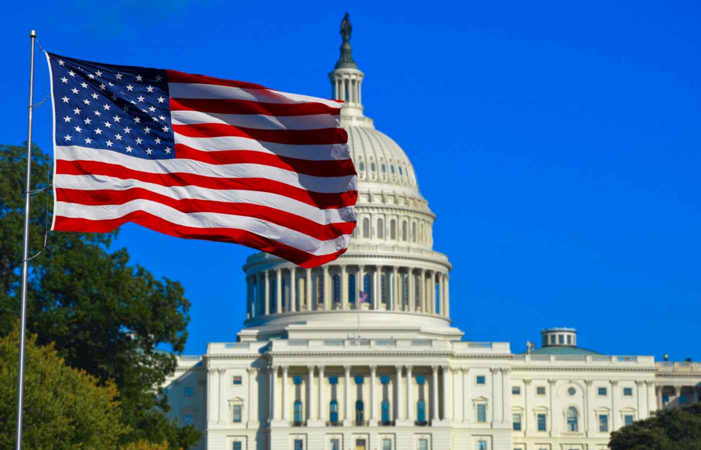 Capitólio em Washington, DC, com uma bandeira dos Estados Unidos ao lado