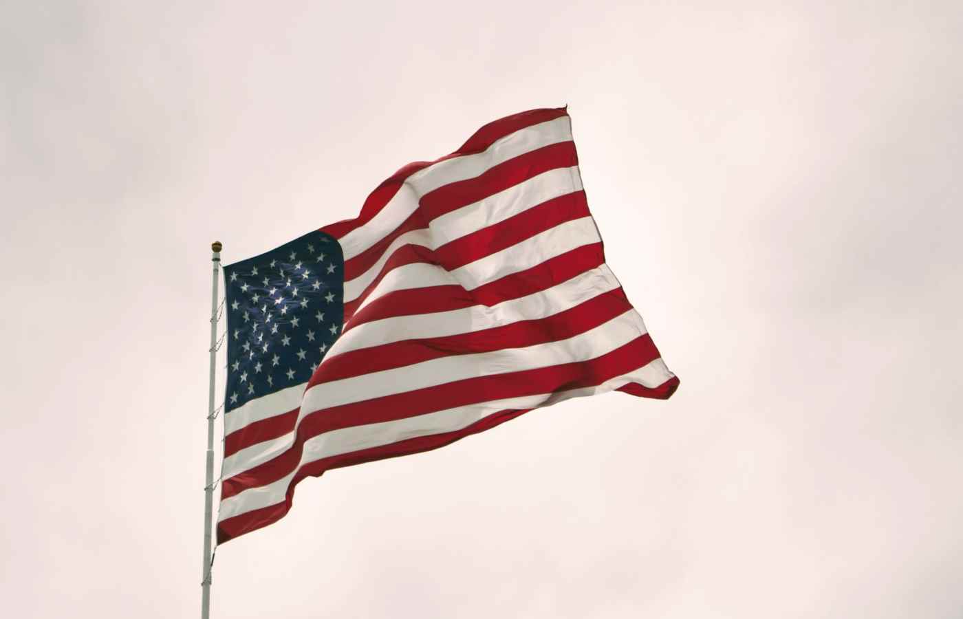 Bandeira dos Estados Unidos balançando no céu nublado