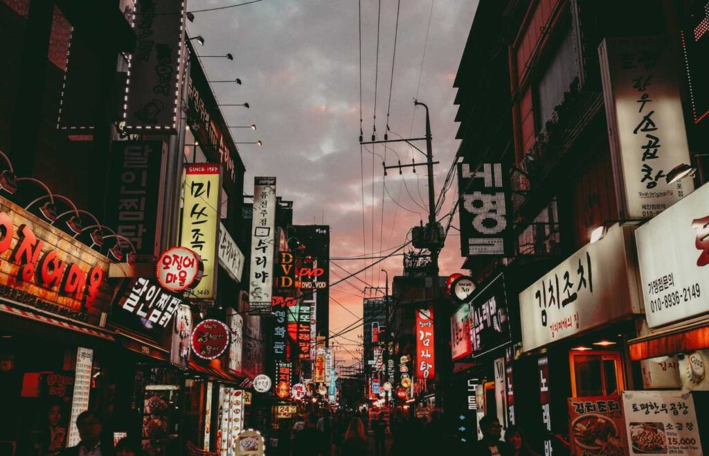 Rua de noite com diversas placas de estabelecimentos na Coreia do Sul