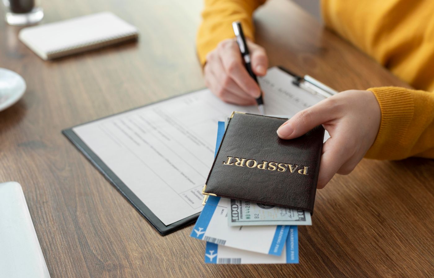 Pessoa segurando passaporte com visto americano e preenchendo um formulário.