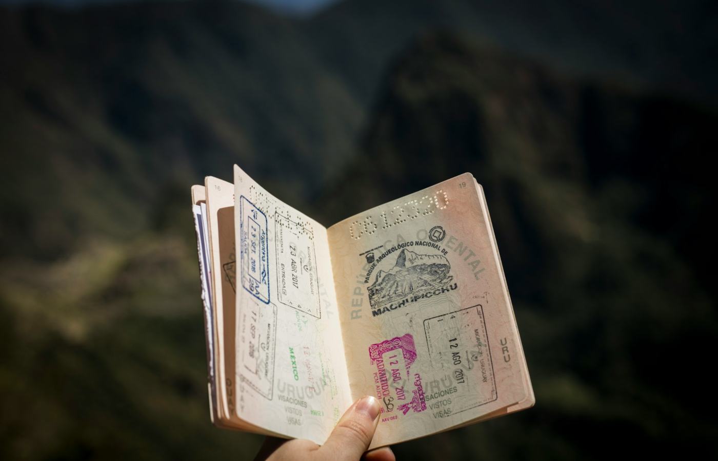 Pessoa segurando passaporte com diversos carimbos