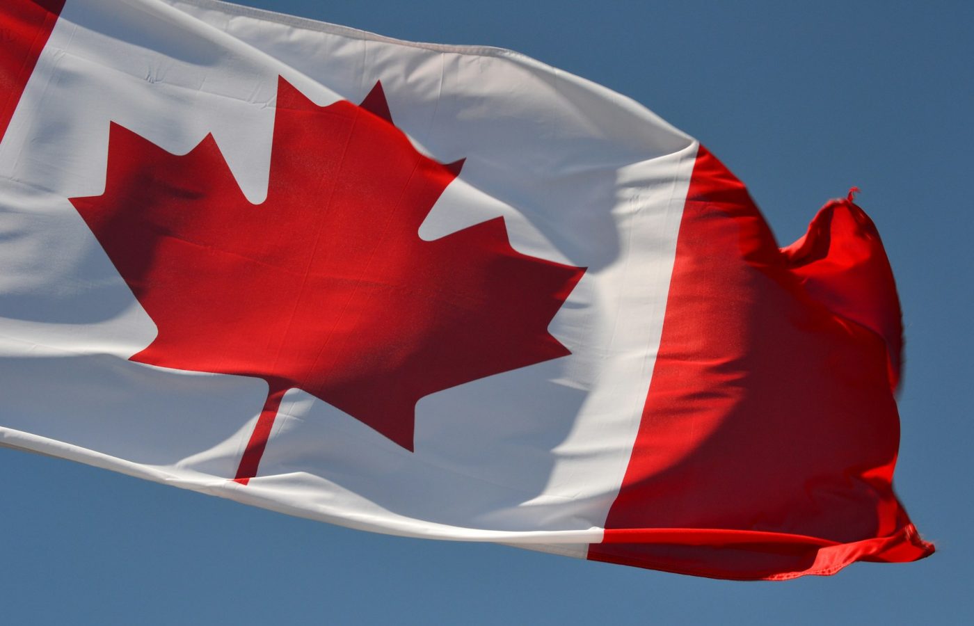 Bandeira do Canadá hasteada ao céu.