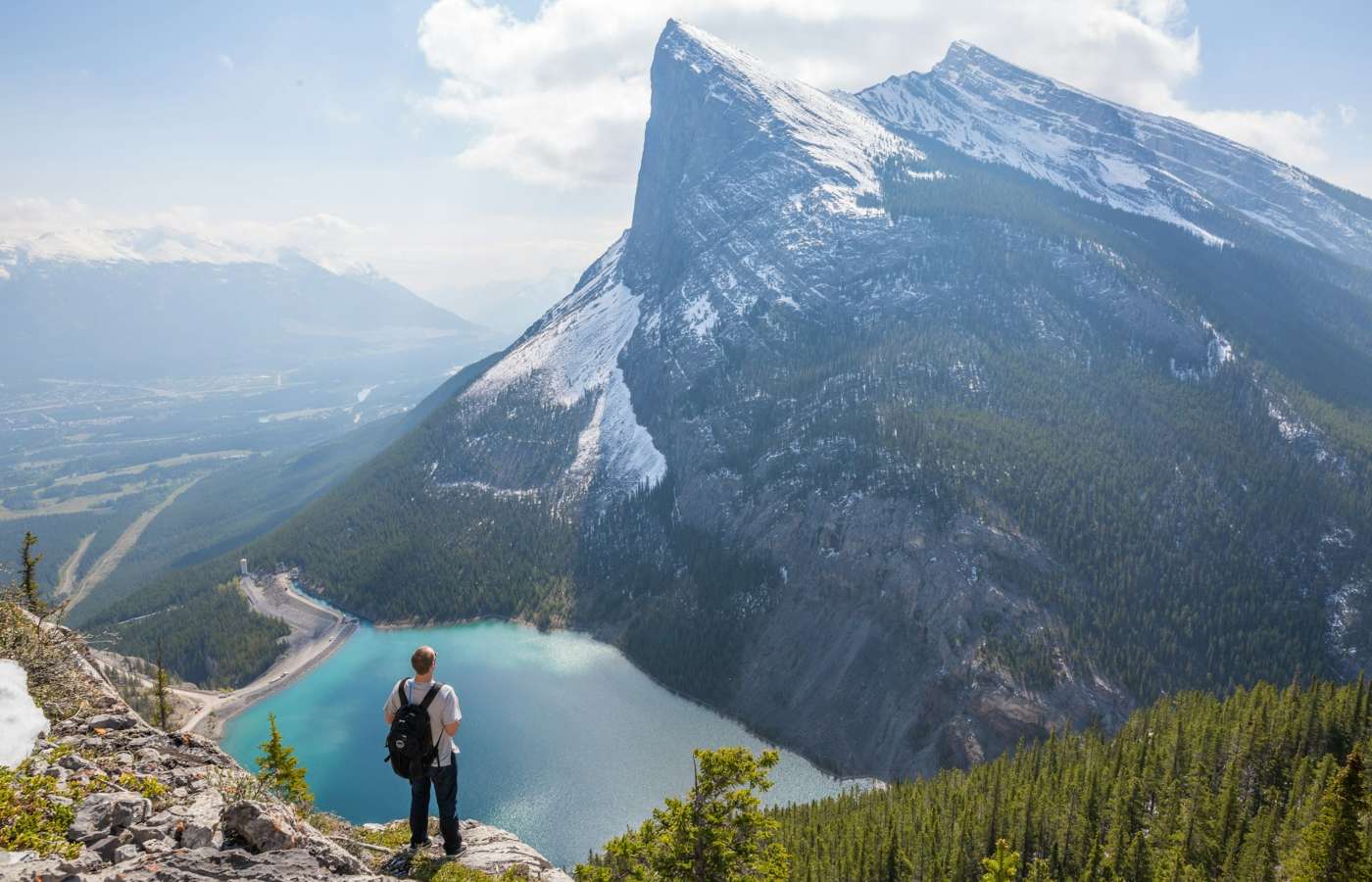 Jovem visitando uma bela paisagem de montanhas com visto de turismo para o Canadá.