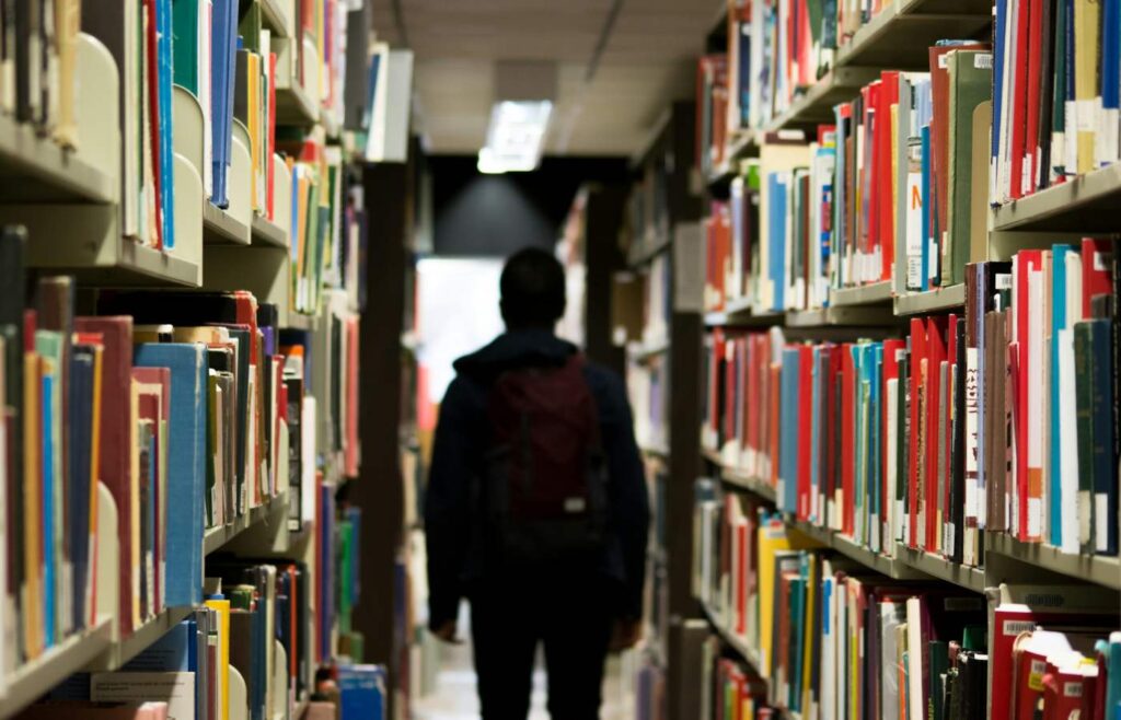 Estudante de intercâmbio na Colômbia numa biblioteca cheia de livros.